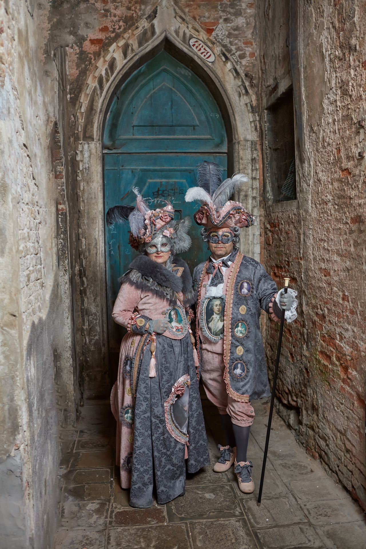Venezianische Maskenträger vor der blauen Tür in Venedig
